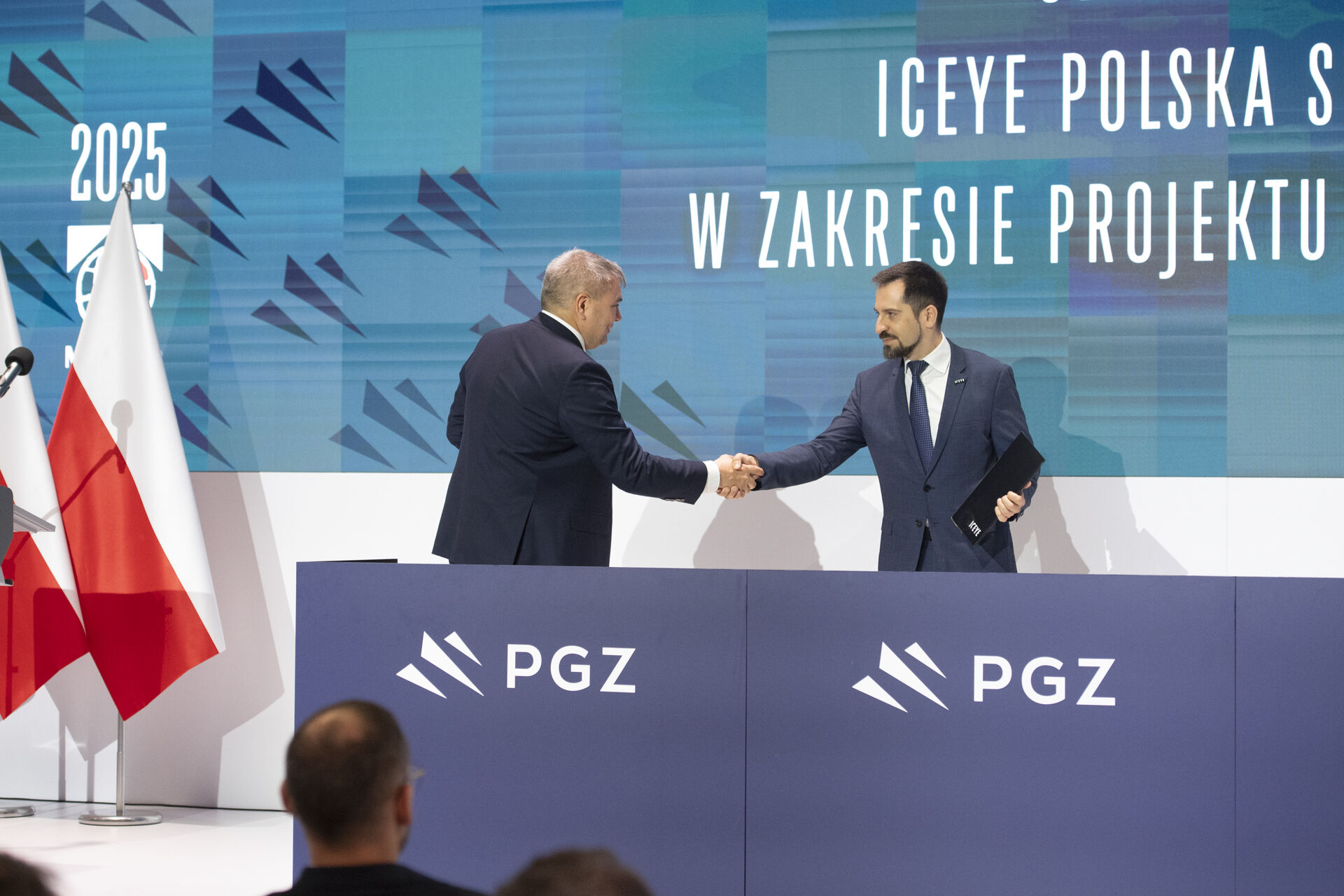 Uścisk dłoni przedstawicieli ICEYE i CTM przy mównicy PGZ — w tle ekran z napisem ICEYE POLSKA i logo Digital Baltic 2025