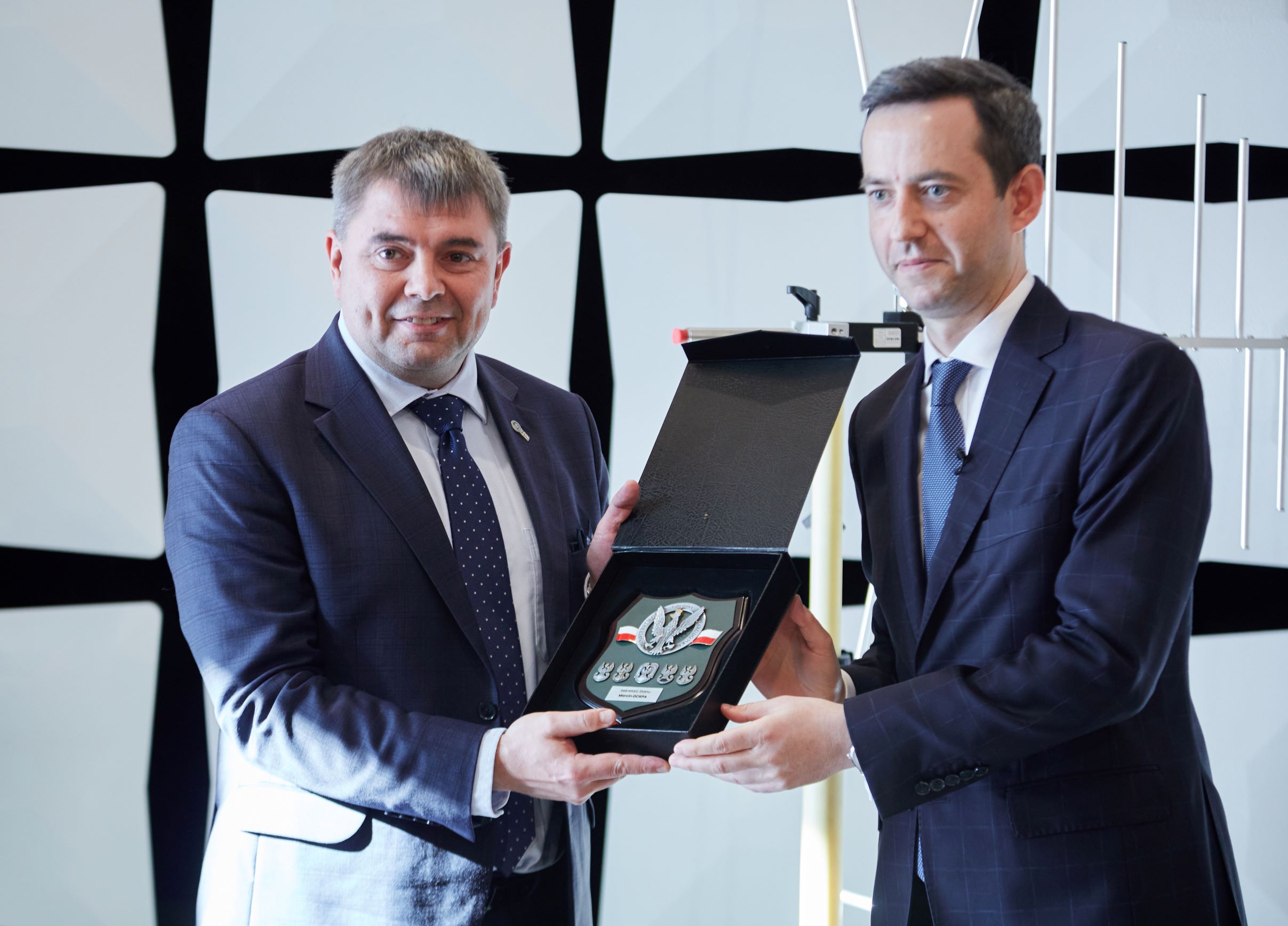 Wręczenie pamiątkowej tablicy z godłem Polski w komorze bezechowej laboratorium EMC LabNet