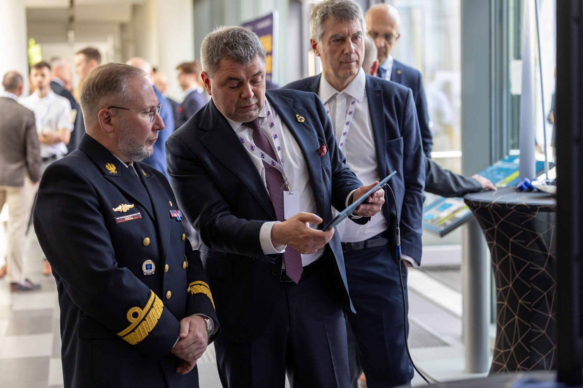 Rozmowy kuluarowe Digital Baltic 2025 — uczestnik pokazuje treść na tablecie oficerowi Marynarki Wojennej