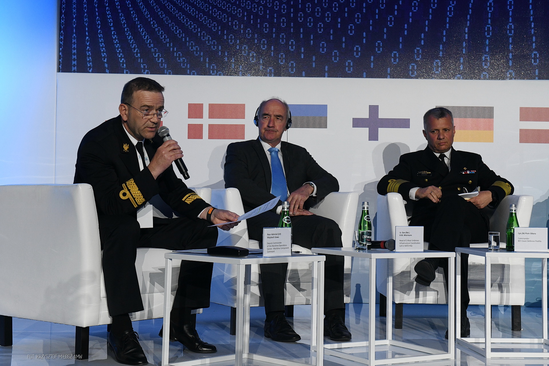 Panel dyskusyjny z kontradmirałem Wojciechem Sową i komandorem Piotrem Sikorą — flagi państw bałtyckich w tle