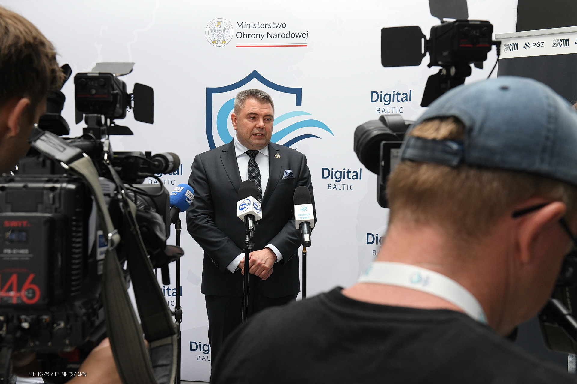 Wywiad medialny na tle ścianki Ministerstwa Obrony Narodowej i Digital Baltic — kamery TVN24 i Polsat News