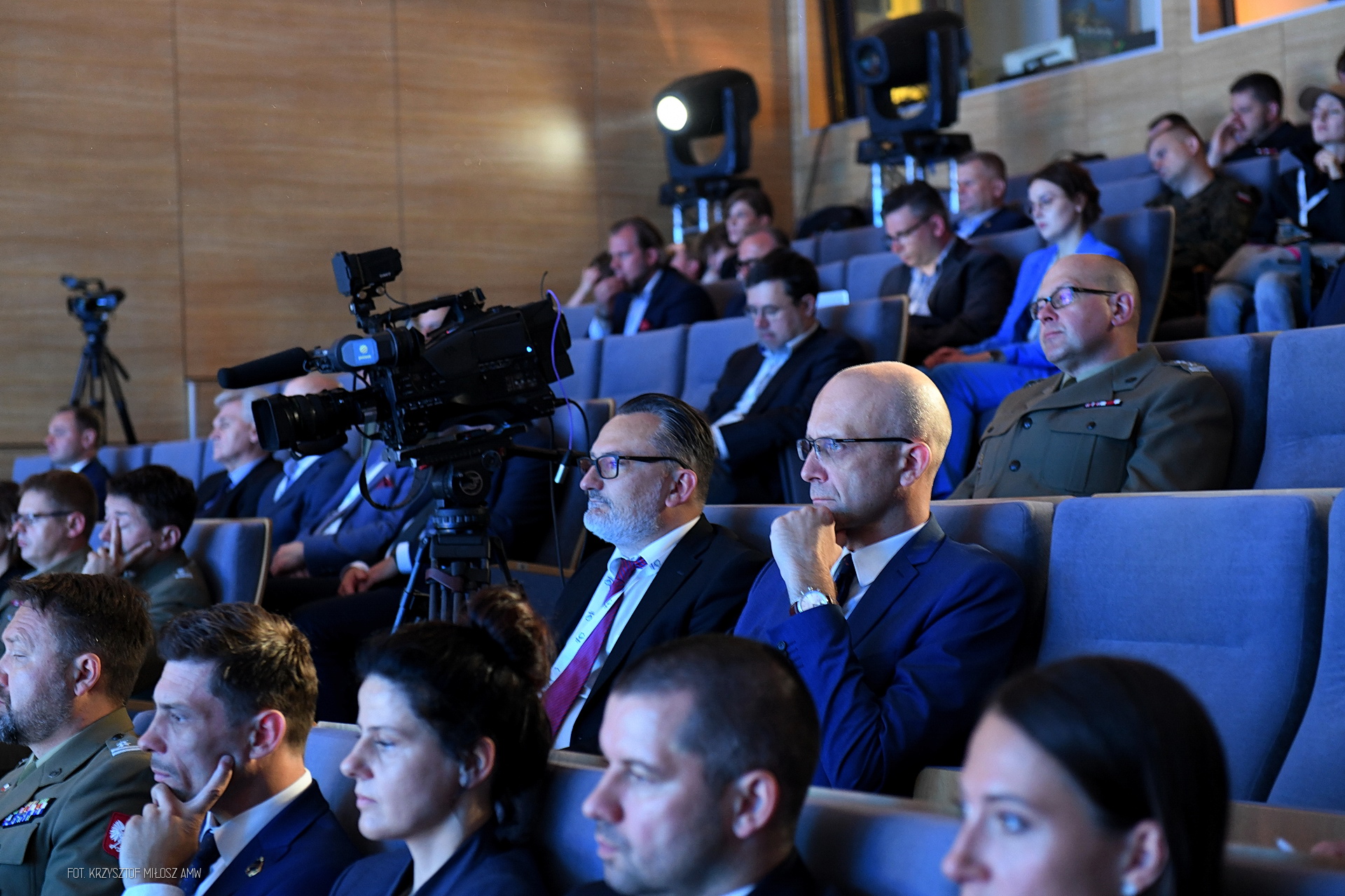Widownia w sali audytoryjnej podczas Digital Baltic — żołnierze w mundurach i profesjonalna kamera telewizyjna