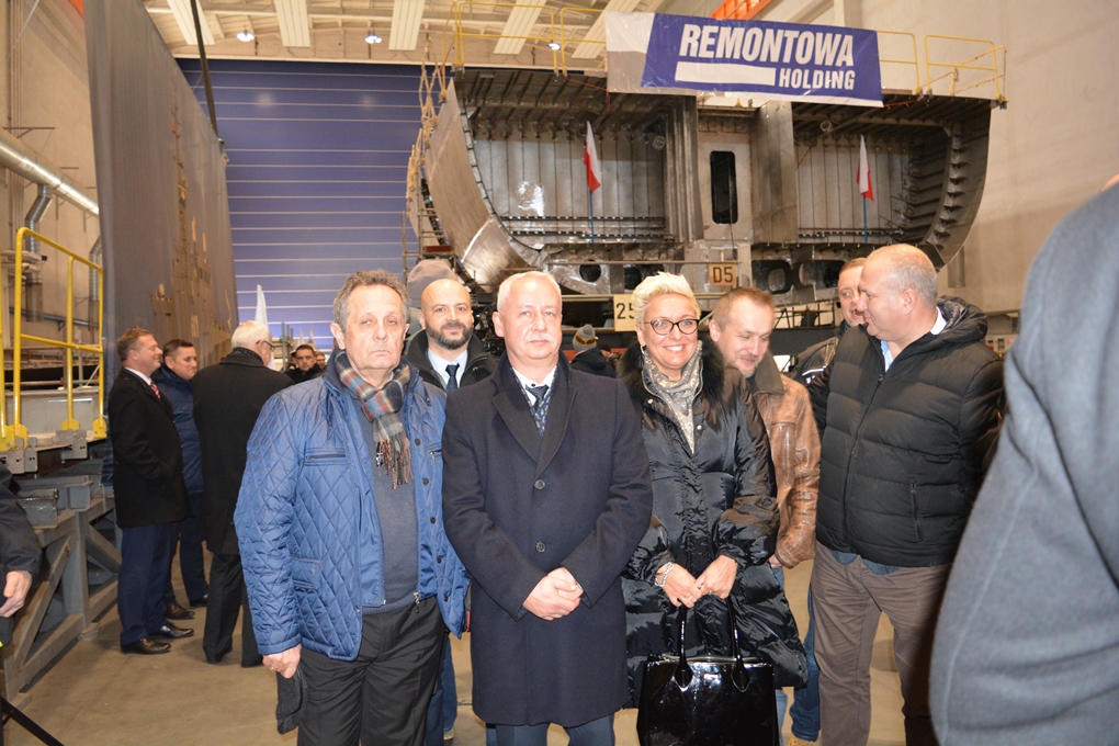 Delegacja podczas położenia stępki ORP Albatros — baner Remontowa Holding i kadłub 258/2