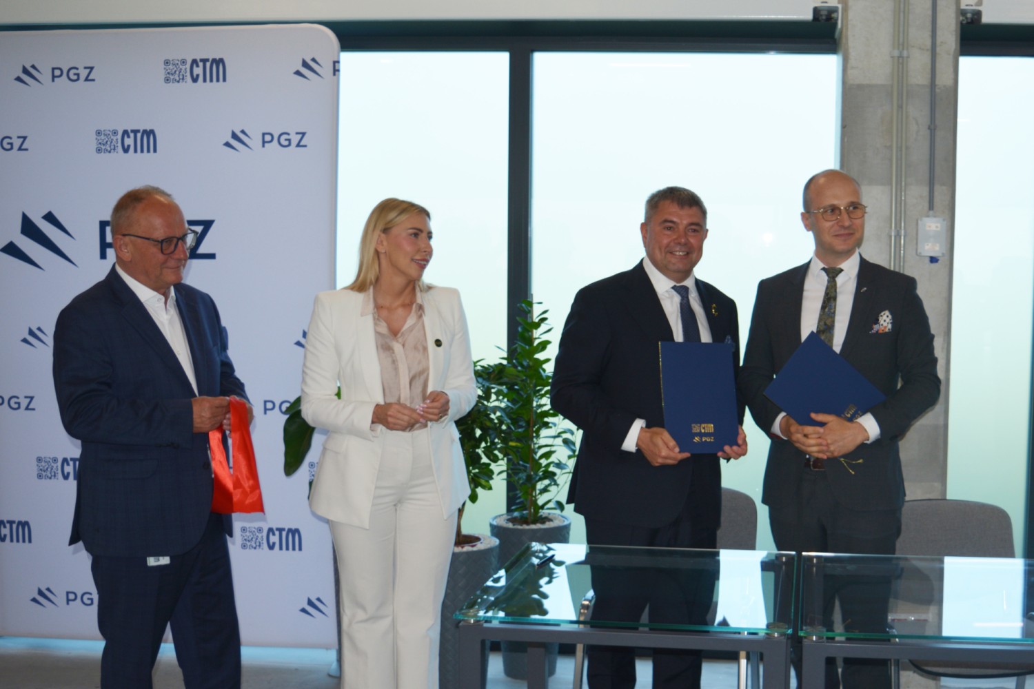 Przedstawiciele po ceremonii otwarcia CEM z pamiątkowymi folderami CTM i PGZ oraz fragmentem czerwonej wstęgi